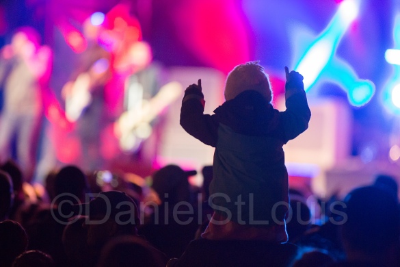 Little girl on dad's shoulders at concert in the park in Moncton.